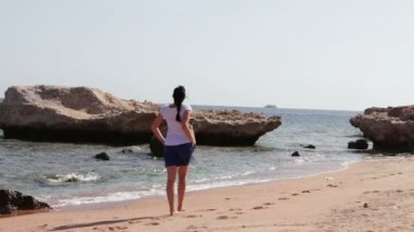 Güzel bacaklar temiz Altın kumlu plaj boyunca çekip genç kadınla