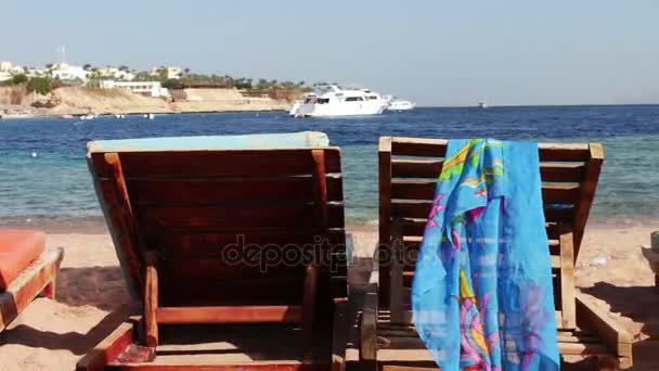 Wooden chair at the beach of background of blue sea and white yacht floats — Stock Video