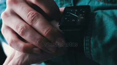 Genç adam akıllı bir saat kullanarak