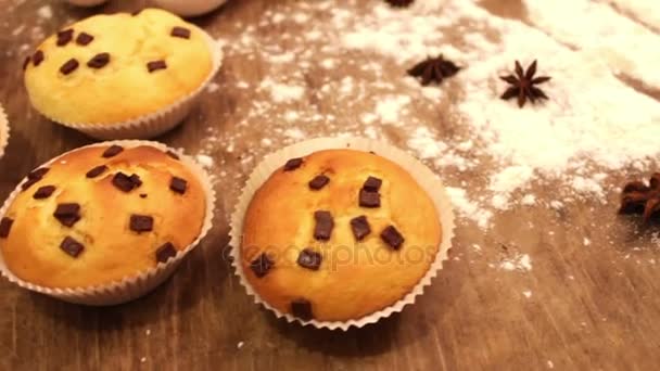 Nybakade muffins med choklad rosiga skivor bevattnas med strösocker i papper bakning — Stockvideo