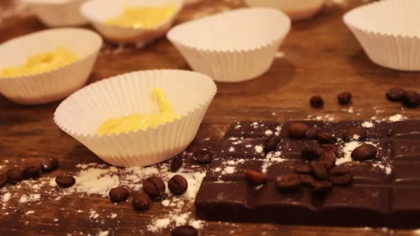 Weibliche Hand legt rohen Teig für Muffins in Papierbackwaren — Stockvideo