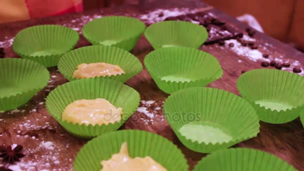 Ženská ruka klade Syrové těsto na muffiny do papíru na pečení — Stock video