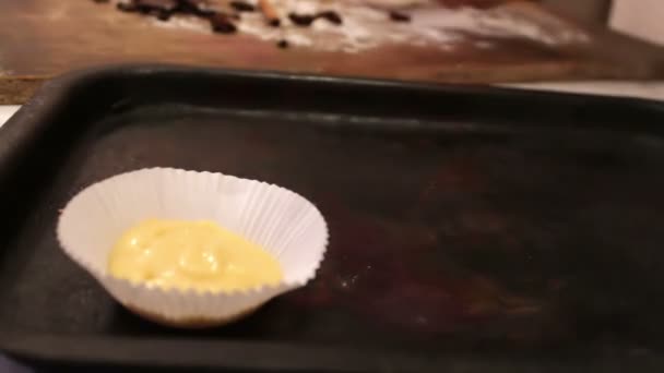 Surowe ciasto na babeczki w specjalny papier do pieczenia danie posypane kawałkami czekolady — Wideo stockowe