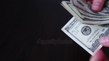 Kadın a yelpaze-in yüz dolar faturaları ve sayıları tutan eller