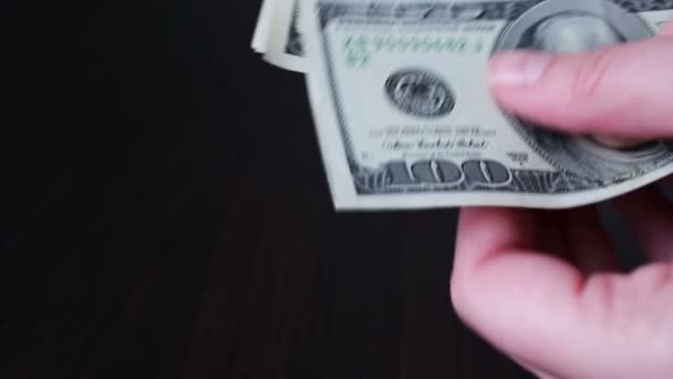 Manos de mujer sosteniendo un ventilador de billetes de cien dólares y cuenta — Vídeos de Stock