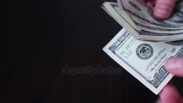 Manos de mujer sosteniendo un ventilador de billetes de cien dólares y cuenta — Vídeo de stock