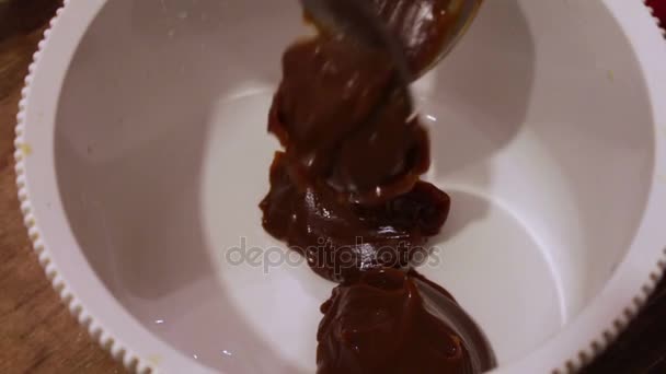 La crema de chocolate se vierte en el recipiente — Vídeo de stock