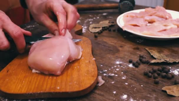 Vrouwelijke handen rauwe kippenvlees snijden — Stockvideo