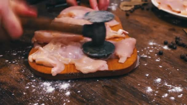 Female hand beats with a hammer chicken fillet — Stock Video
