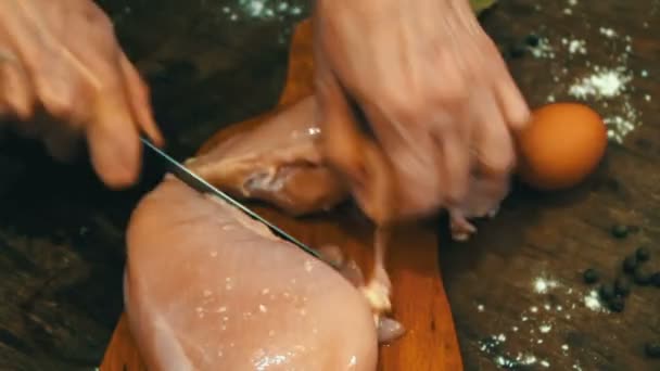 Manos femeninas cortando carne de pollo cruda — Vídeo de stock