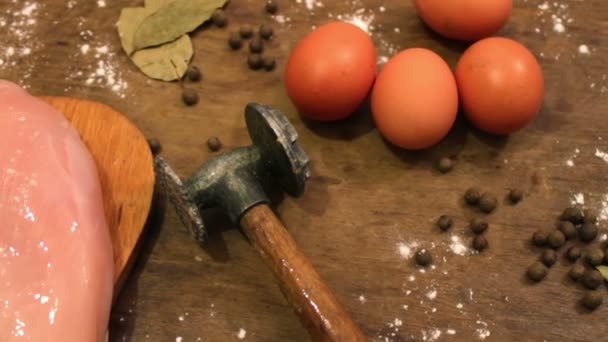Tavuk fileto et dövdüğü için çiğ yumurta çekiç yanındaki masada — Stok video
