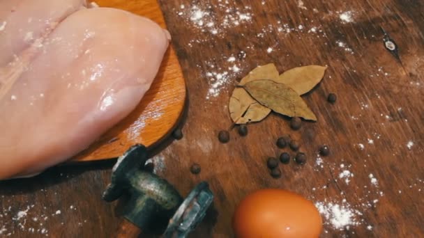 Filet de poulet sur la table à côté des œufs crus marteau pour battre la viande — Video