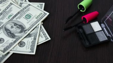 Yüz dolar faturaları ve kozmetik masada.