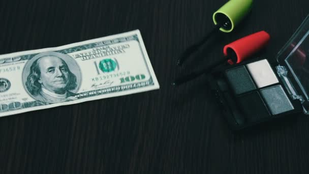 Sto dolarové bankovky a kosmetiku na stůl. — Stock video