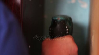 Bir adam duvara elektrikli matkap ile girer.