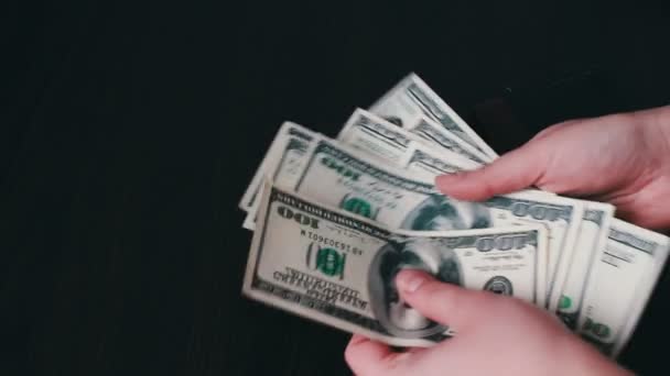 Mãos de mulher segurando um fã de notas de cem dólares e conta — Vídeo de Stock
