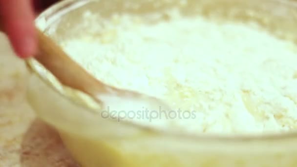 Женская рука месит сырое тесто деревянной ложкой — стоковое видео
