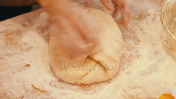 As mãos femininas amassam a massa de farinha na mesa — Vídeo de Stock