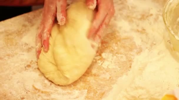 Manos femeninas amasando masa en harina sobre la mesa — Vídeos de Stock