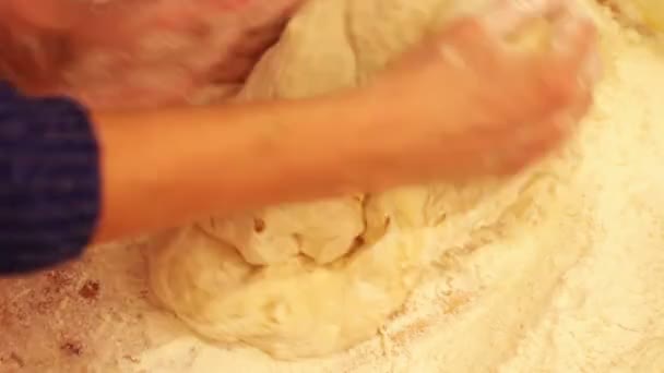 Manos femeninas amasando masa en harina sobre la mesa — Vídeos de Stock