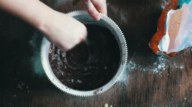 Çikolatalı kurabiye hamuru beyaz bir plastik kapta bir kaşıkla karıştırarak Üstten Görünüm