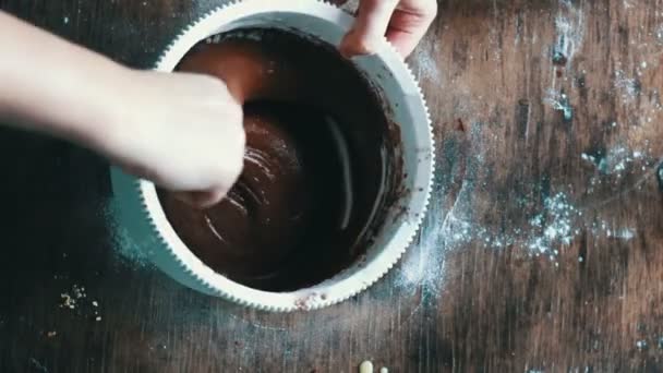 Vista dall'alto mescolando la pasta di biscotti al cioccolato con un cucchiaio in una ciotola di plastica bianca — Video Stock