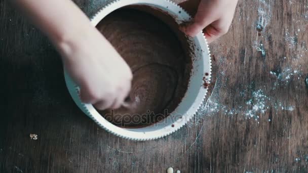 Bovenaanzicht chocolade koekjesdeeg roeren met een lepeltje in een witte plastic kom — Stockvideo