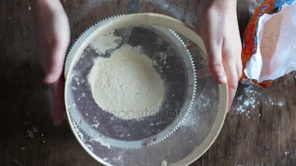 Top view of woman sieving flour in plate — Stock Video