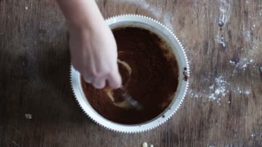Çikolatalı kurabiye hamuru beyaz bir plastik kapta bir kaşıkla karıştırarak Üstten Görünüm