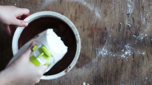 Ovanifrån omrörning choklad cookie degen med elvisp i en vit plast skål — Stockvideo