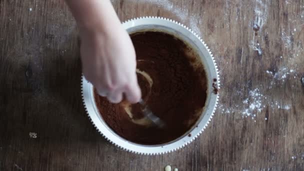 Το Top view ανακατεύοντας ζύμη μπισκότο σοκολάτας με ένα κουτάλι σε ένα λευκό πλαστικό μπολ — Αρχείο Βίντεο