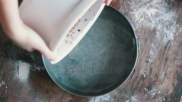 Top view of woman pours a chocolate tough in a baking tray — стоковое видео