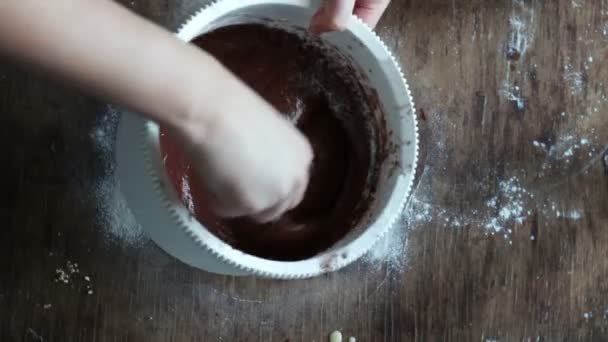 상위 뷰는 흰색 플라스틱 그릇에 스푼으로 초콜릿 쿠키 반죽을 저 어 — 비디오