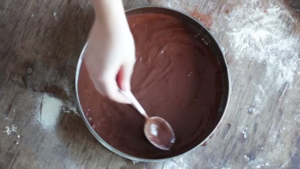 Een vrouw giet een chocolade deeg in een bakken lade en worden het — Stockvideo