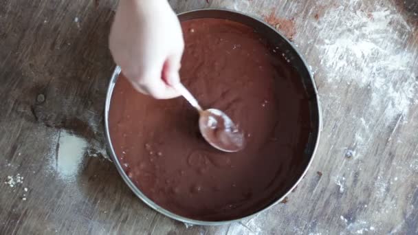 Una mujer vierte una masa de chocolate en una bandeja para hornear y lo suaviza — Vídeos de Stock