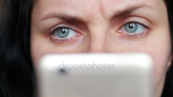 Крупным планом женщина глаз глядя смартфон — стоковое видео