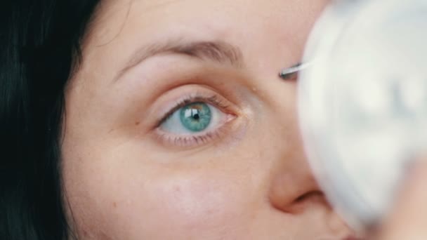 Kvinna plockar ögonbryn hårborttagning med pincett. — Stockvideo
