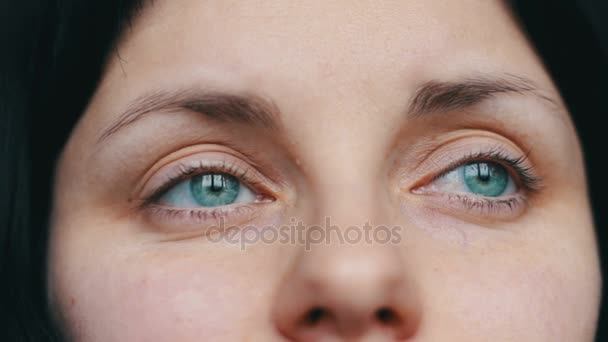 Groen-eyed vrouwelijke gezicht ziet er weg en tot de camera. Close-up beeld met verdrietig meisje — Stockvideo