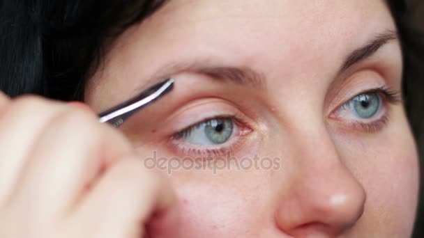 Frau zupft Augenbrauen mit Pinzette ab — Stockvideo