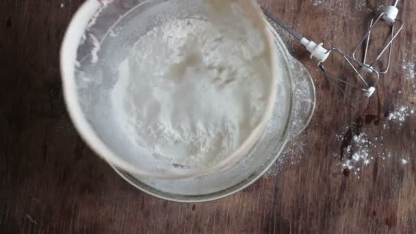 Top view of woman sieving flour the plate — Stock Video