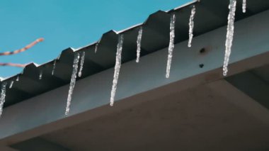 Bir çatı üzerinde eriyen buz sarkıtları
