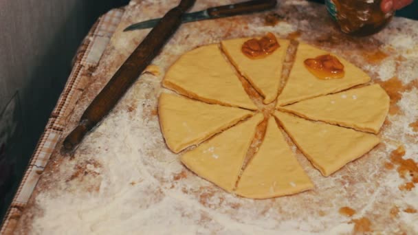 A woman puts on fresh pieces of dough apricot jam — Stock Video