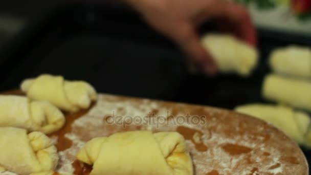 Hausgemachte Croissants, die auf einem Backblech ausgebreitet werden — Stockvideo