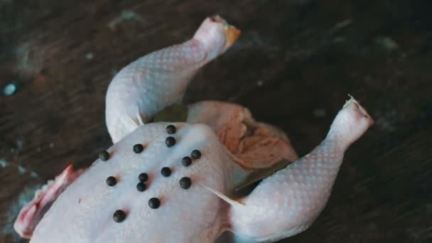 Hands preparing whole raw chicken on a wooden cooking board — Stock Video