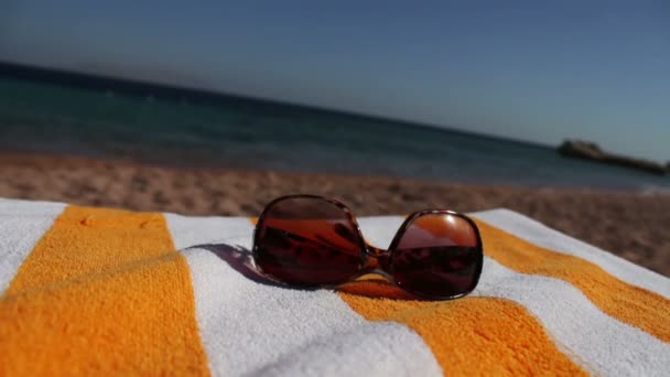 Gafas de sol tumbadas en una tumbona — Vídeos de Stock