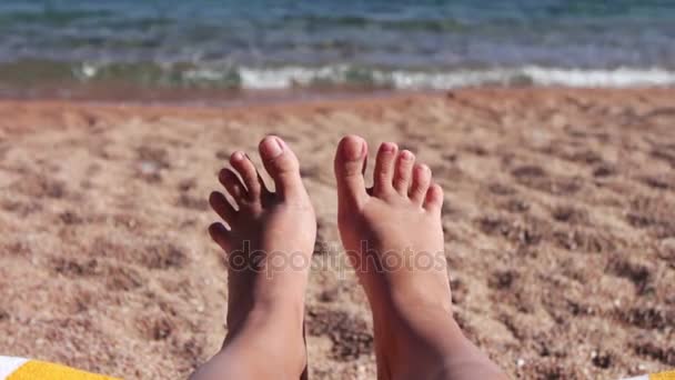 Τα πόδια βρίσκονται σε μια ξαπλώστρα στην παραλία — Αρχείο Βίντεο