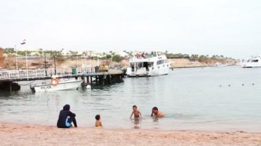 Mısır, South Sinai, Sharm El Sheikh, 29 Kasım 2016: Denizde Müslüman aile banyoları. Bir kadında bir hijab çocukları ile yüzmek Kızıldeniz '.