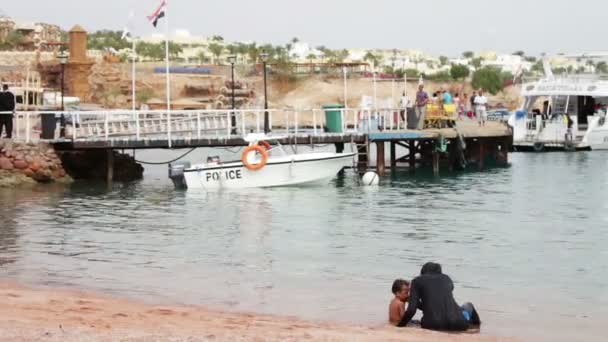 EGITO, SINAI DO SUL, SHARM EL SHEIKH, NOVEMBRO 29, 2016: A família muçulmana banha-se no mar. Uma mulher em hijab com seus filhos nadar no Mar Vermelho . — Vídeo de Stock