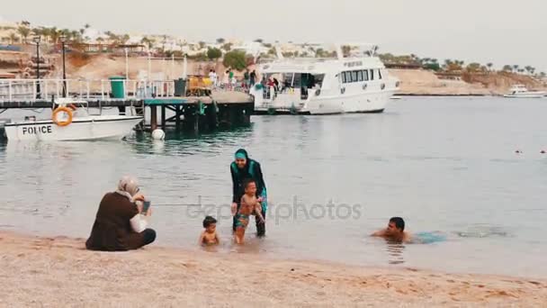 Єгипет, Південний Синай, Шарм-Ель-Шейх, 29 листопада 2016: Мусульманської родини ванни в море. Жінка в хіджаб зі своїми дітьми плавати в Червоному морі. — стокове відео