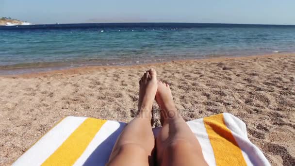 Jambes allongées sur une chaise longue sur la plage — Video